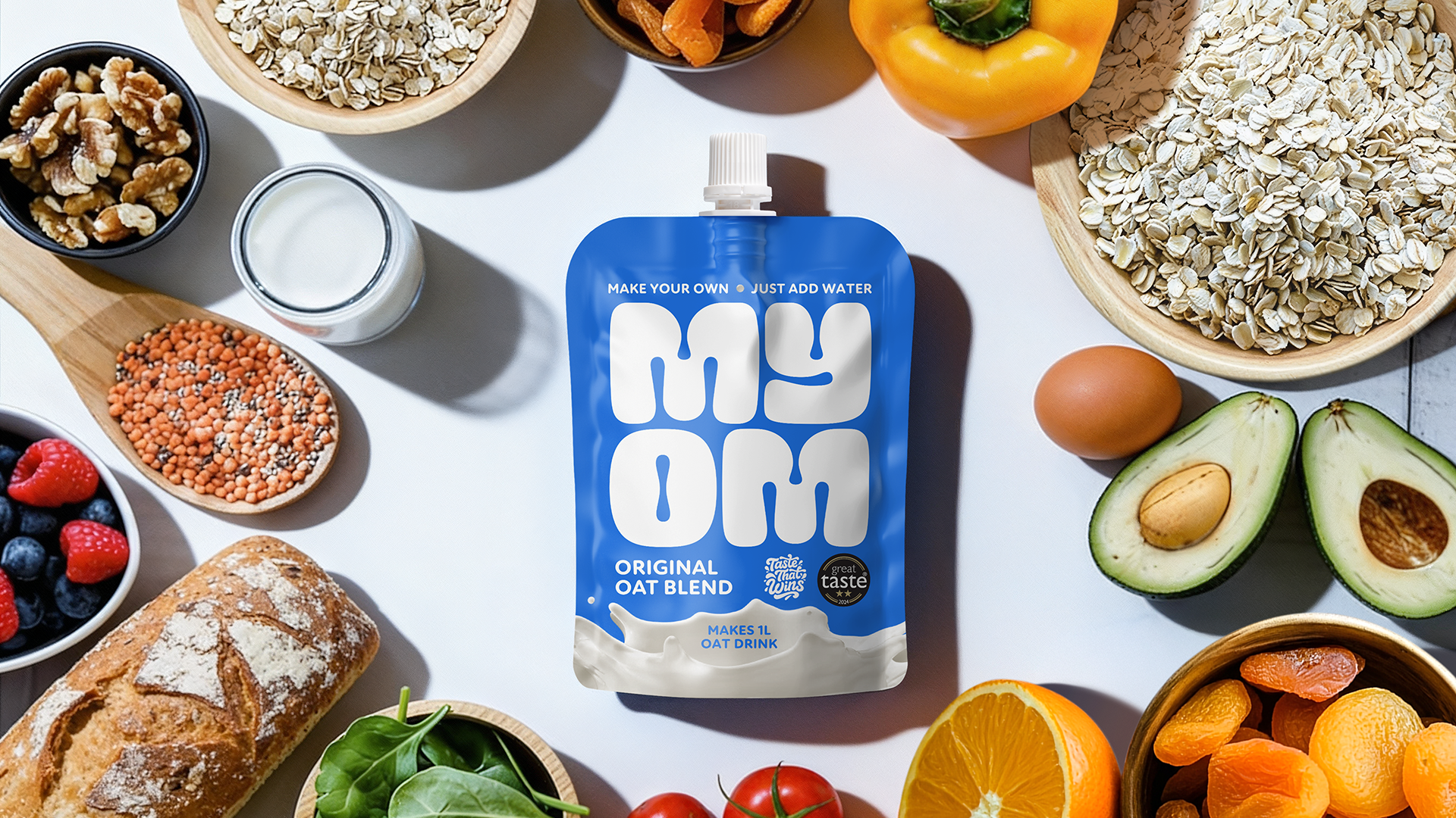 MYOM Original Oat milk pouch surrounded by healthy breakfast foods, illustrating a low-calorie oat milk option suitable for a GLP-1 diet