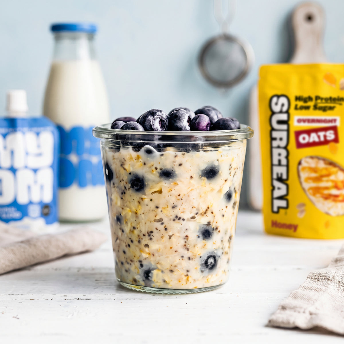 Surreal Honey Overnight Oats made hot with MYOM Original oat drink and fresh blueberries, a warm low sugar porridge-style breakfast.