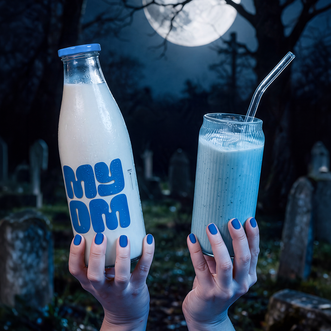 Blue MYOM Blue Moon shake beside a MYOM glass bottle, held by blue hands beneath a full moon.